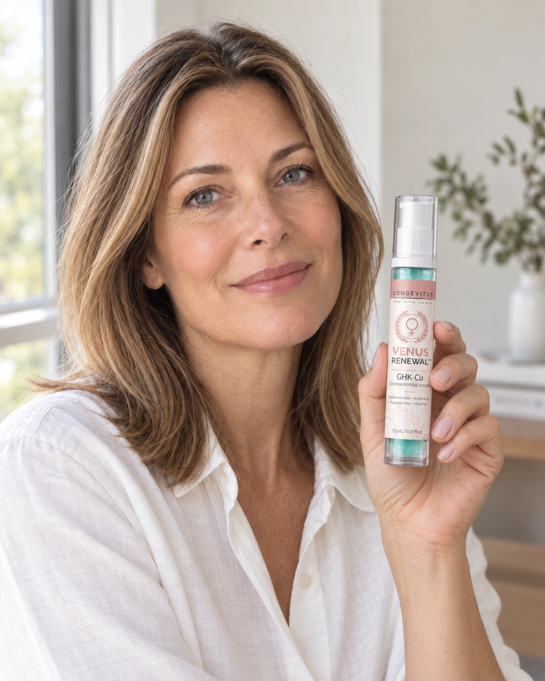 Woman holding a 15 mL Venus Renewal GHK-Cu bottle in soft window daylight
